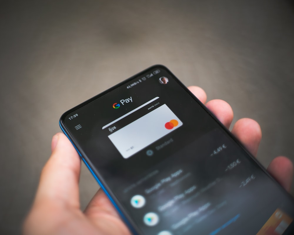 A Hand Holding a Phone Showing the Google Pay app