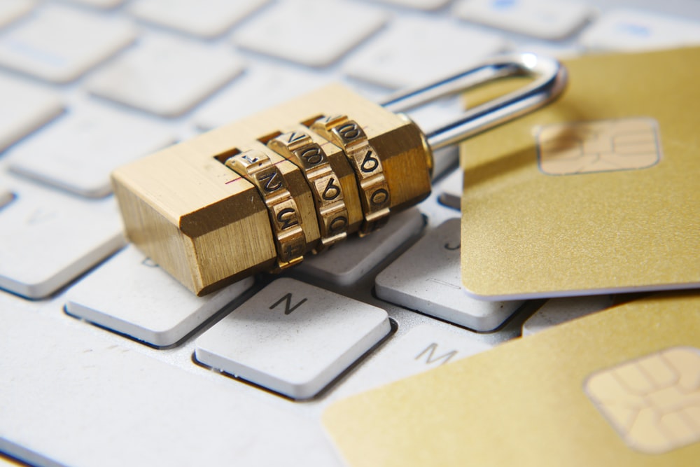 A Golden Padlock and Two Credit Cards Lying on Top of a White Keyboard